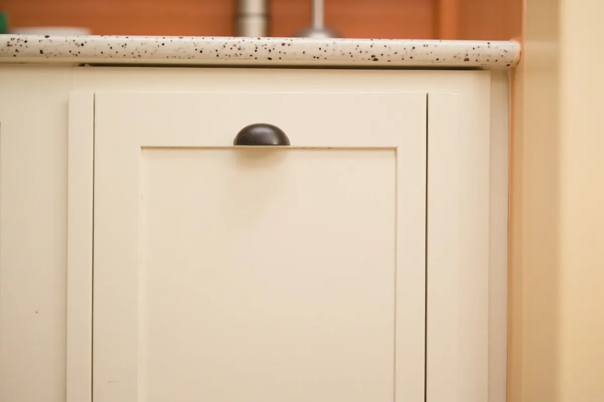 Refinished shaker kitchen cabinets in off-white with updated hardware